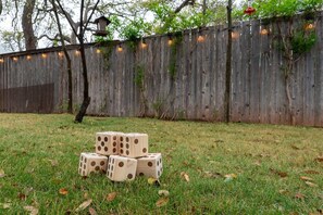 A grassy area with a wooden fence and string lights. - Boho Buffalo: Luxe Texas Hideaway in The Gap (Buffalo Gap)