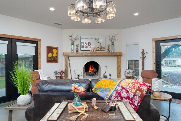 A living room with a fireplace, leather sofa, and a coffee table with decorative items.