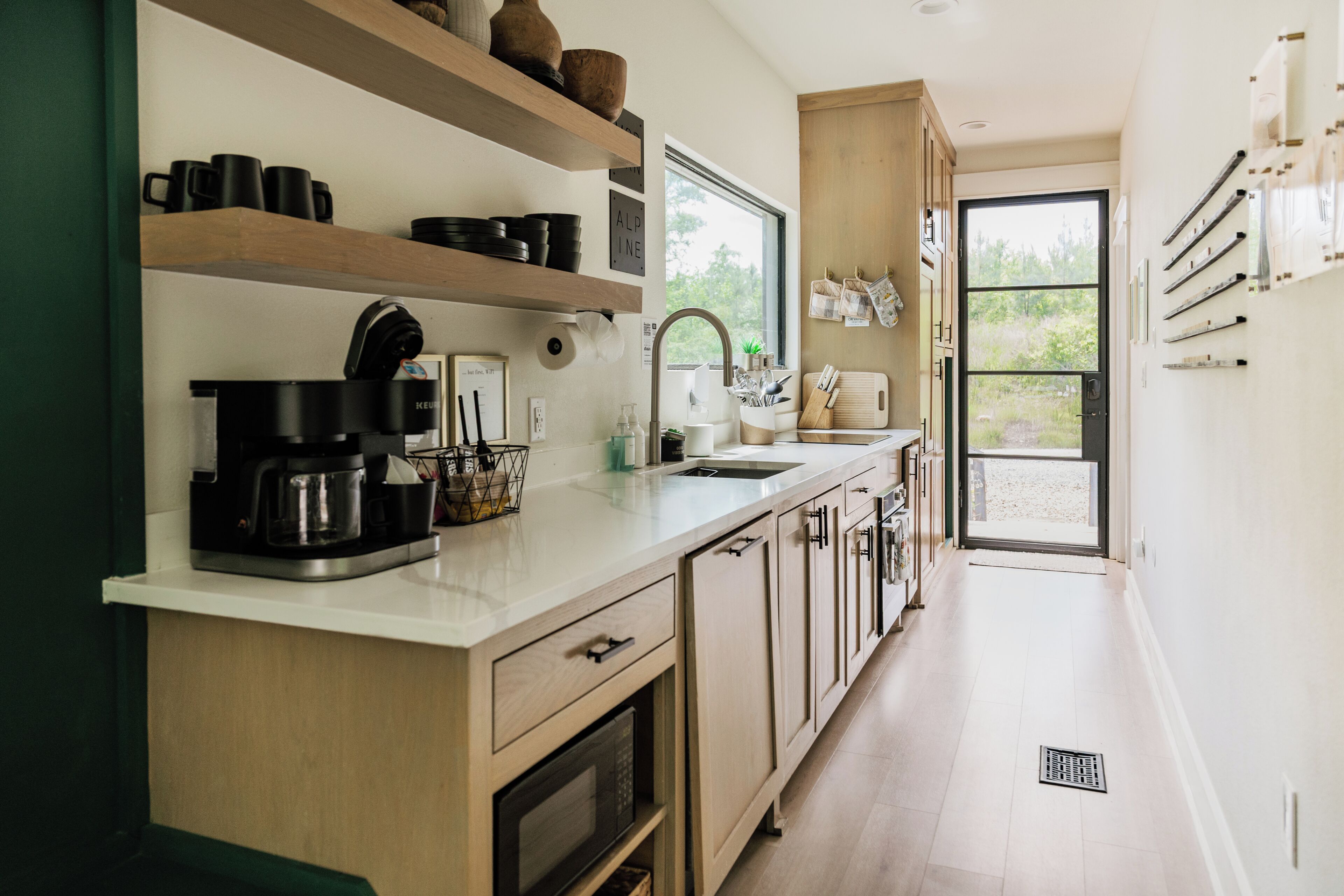 Une cuisine moderne avec des meubles en bois, une machine à café et un évier.