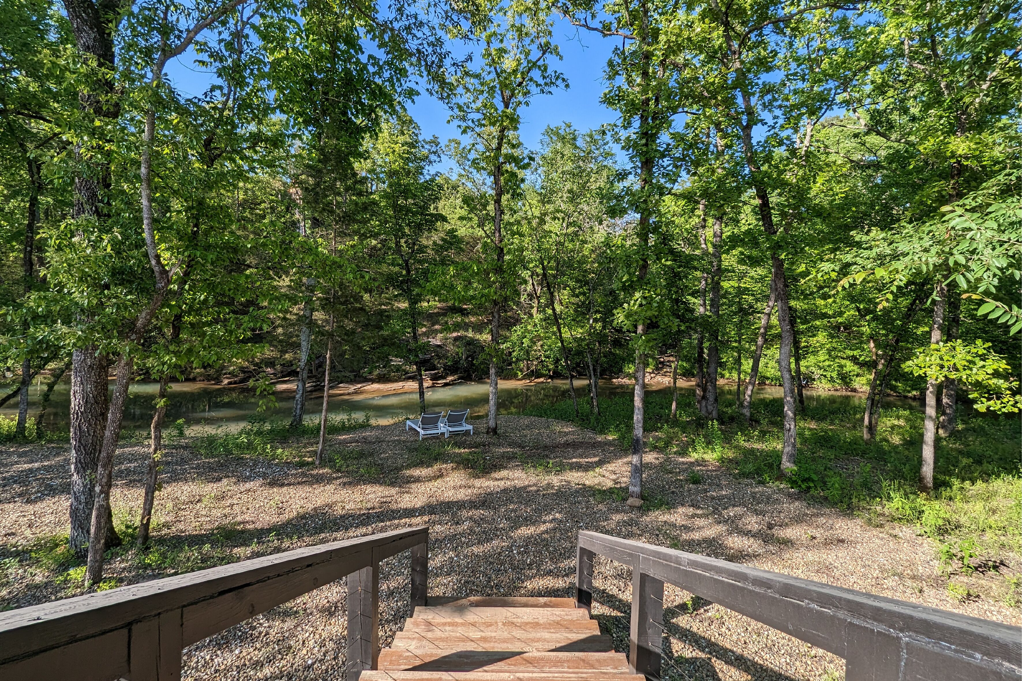 A wooden staircase leading to a park area with benches and a pond.