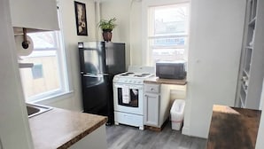 A compact kitchen with a refrigerator, stove, microwave, and a small window. - Updated studio 7 minute walk to beach.  FREE Park! (Old Orchard Beach)