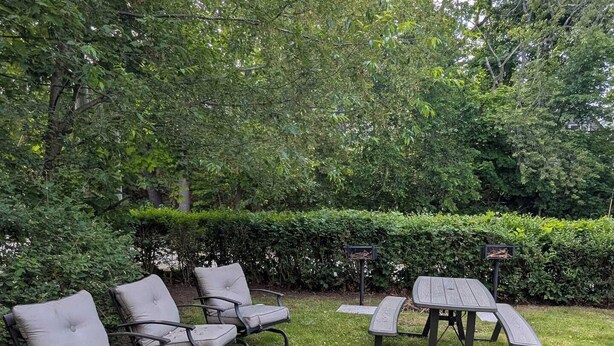 A grassy outdoor area with a fire pit, a table, and several chairs. - Updated studio 7 minute walk to beach.  FREE Park! (Old Orchard Beach)