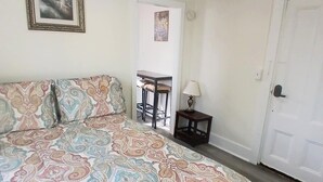 A bedroom with a bed, a small table with chairs, a lamp, and a door. - Updated studio 7 minute walk to beach.  FREE Park! (Old Orchard Beach)