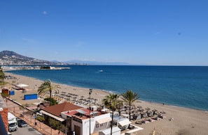 A coastal hotel with beach access, a view of the sea, and a mountain in the background. - Ref: 262 Beach front apartment with amazing terrace and sea views (Fuengirola)