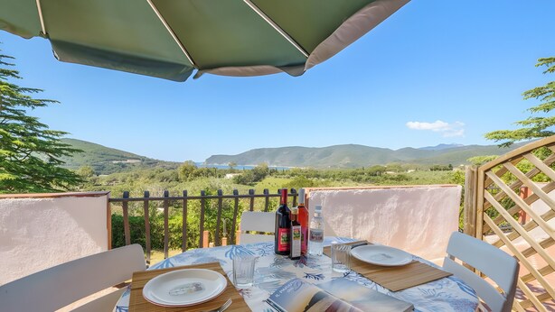 A table set outdoors with a view of hills and a clear sky.