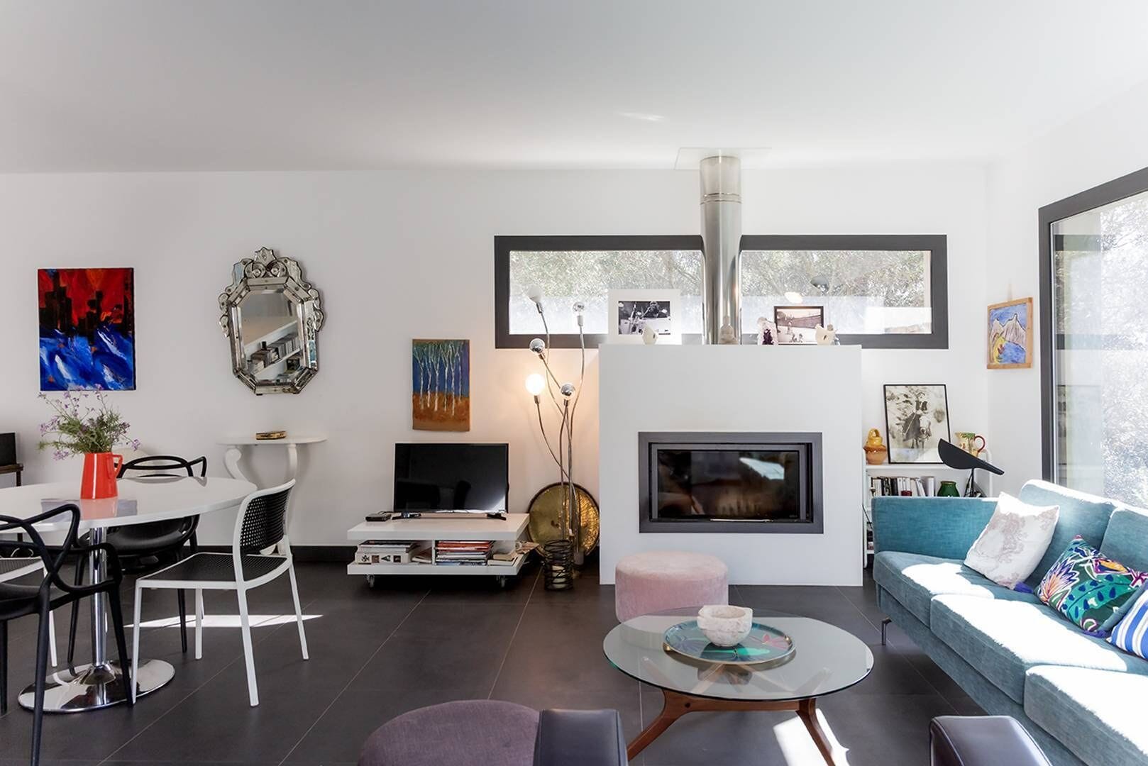 A modern living room with a TV, sofa, and dining area.