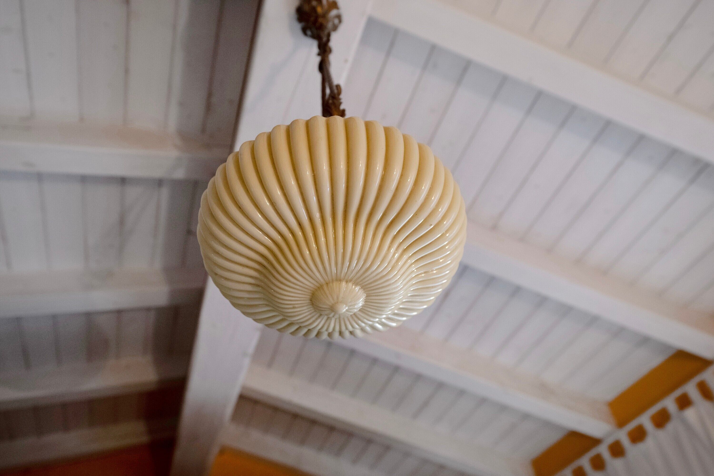 Eine dekorative, gerippte, sphärische Leuchte an der Decke.
