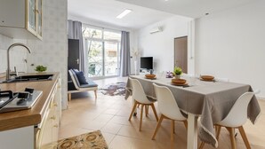 Een moderne keuken met een eethoek, een flatscreen televisie en uitzicht op de omgeving.