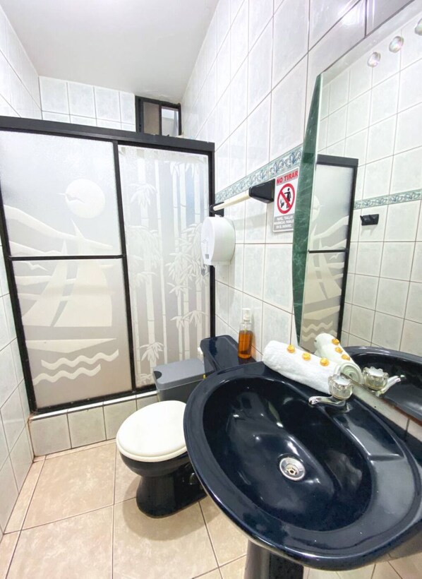 Ein Badezimmer mit Toilette, Waschbecken und Spiegel. An der Wand befindet sich ein Schild mit der Aufschrift 'No Toilet Paper'.