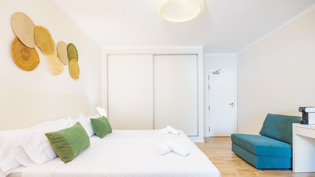 A hotel room with a bed, a desk, a chair, and a wardrobe. - Hostal Boutique Canyamel, 112 Double Room with Sea View, Private Terrace, Wi-Fi and Air Conditioning (Canyamel)
