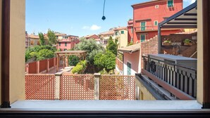 Un balcón con vistas a una zona residencial, que incluye casas y vegetación.