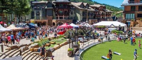 A bustling outdoor area with a pool, surrounded by buildings with traditional architecture.