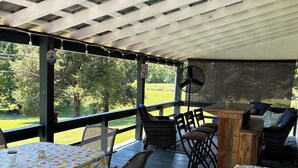 Une terrasse extérieure avec deux tables, des chaises et un ventilateur.
