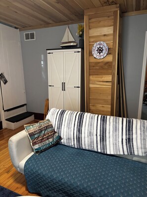 Ein gemütliches Zimmer mit einem gestreiften Sofa, einer Holztür und einer Uhr an der Wand.