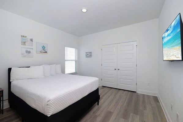 A bedroom with a bed, a wardrobe, a window, and wall decorations. - 5-bedroom house in fabulous Santa Rosa Beach with Pool, Firepit, BBQ (Santa Rosa Beach)