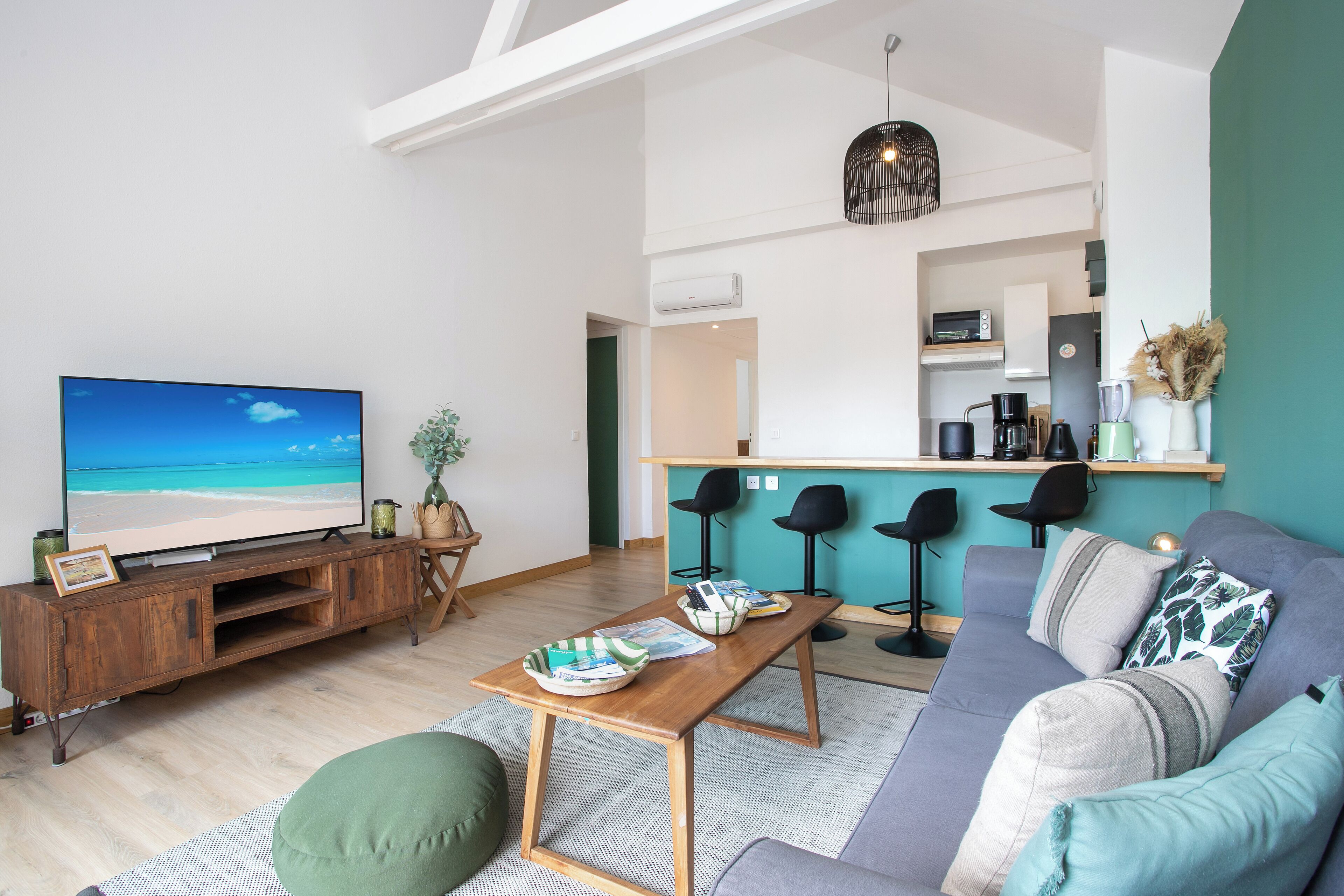 Un soggiorno moderno con televisione, mobile TV in legno e divano.