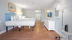 Ein Schlafzimmer mit Bett, Schminktisch, Lampe und Bildern an den Wänden.