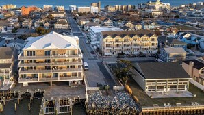 A coastal hotel with multiple floors, a dock, and a view of the sea. - Updated 1st floor, 1-bedroom, 2-Queen bed condo. Close to parks, beach, & boards (Ocean City)
