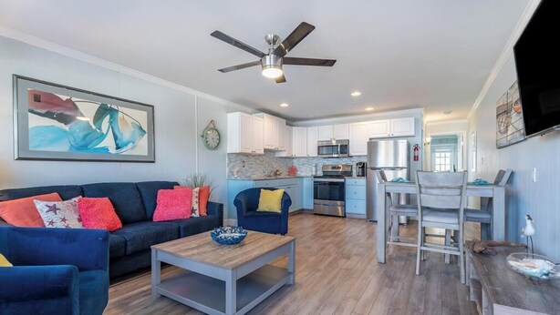 A modern living room with a sofa, coffee table, and a dining area with chairs and a table. - Updated 1st floor, 1-bedroom, 2-Queen bed condo. Close to parks, beach, & boards (Ocean City)