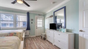A bedroom with a bed, dresser, TV, and a large mirror. - Updated 1st floor, 1-bedroom, 2-Queen bed condo. Close to parks, beach, & boards (Ocean City)