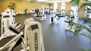 A gym with various exercise machines, including treadmills and weight stations, with a carpeted floor and potted plants. - 1-bedroom villa in charming Indio with AC, WiFi, fitness room (Indio)