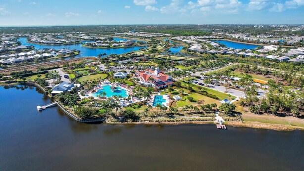 An aerial view of a resort with multiple swimming pools, a central building, and surrounding greenery. - Saona Cottage - Coastal Elegance (Naples)
