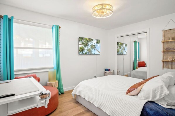 Une chambre moderne avec un grand lit, un bureau et une fenêtre avec des rideaux.