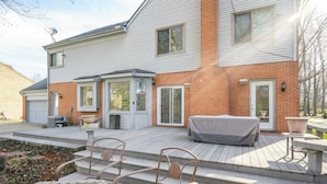 A two-story house with a covered patio, outdoor seating, and a satellite dish. - Luxurious Dream Home For 10! (Loveland)