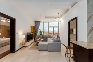 A modern living room with a sectional sofa, a small round table, and a bar area.