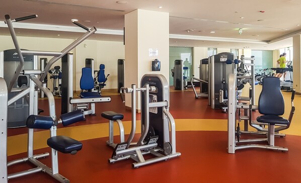 A gym with various exercise machines, including weight benches and cardio equipment.