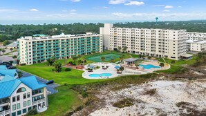 A large hotel with multiple floors, a central courtyard with a swimming pool, and a beach area. - Flash Sale 2BR/2BA Gulf View | Sleeps 8 (Gulf Shores)