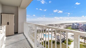 A balcony with a view of a beach and a pool area. - Flash Sale 2BR/2BA Gulf View | Sleeps 8 (Gulf Shores)