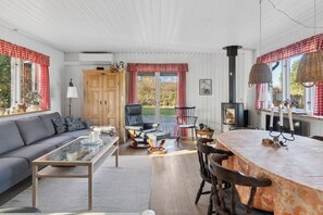 Ein gemütliches Wohnzimmer mit einer Couch, einem Glastisch, einem Kamin und einem Essbereich mit Tisch und Stühlen.