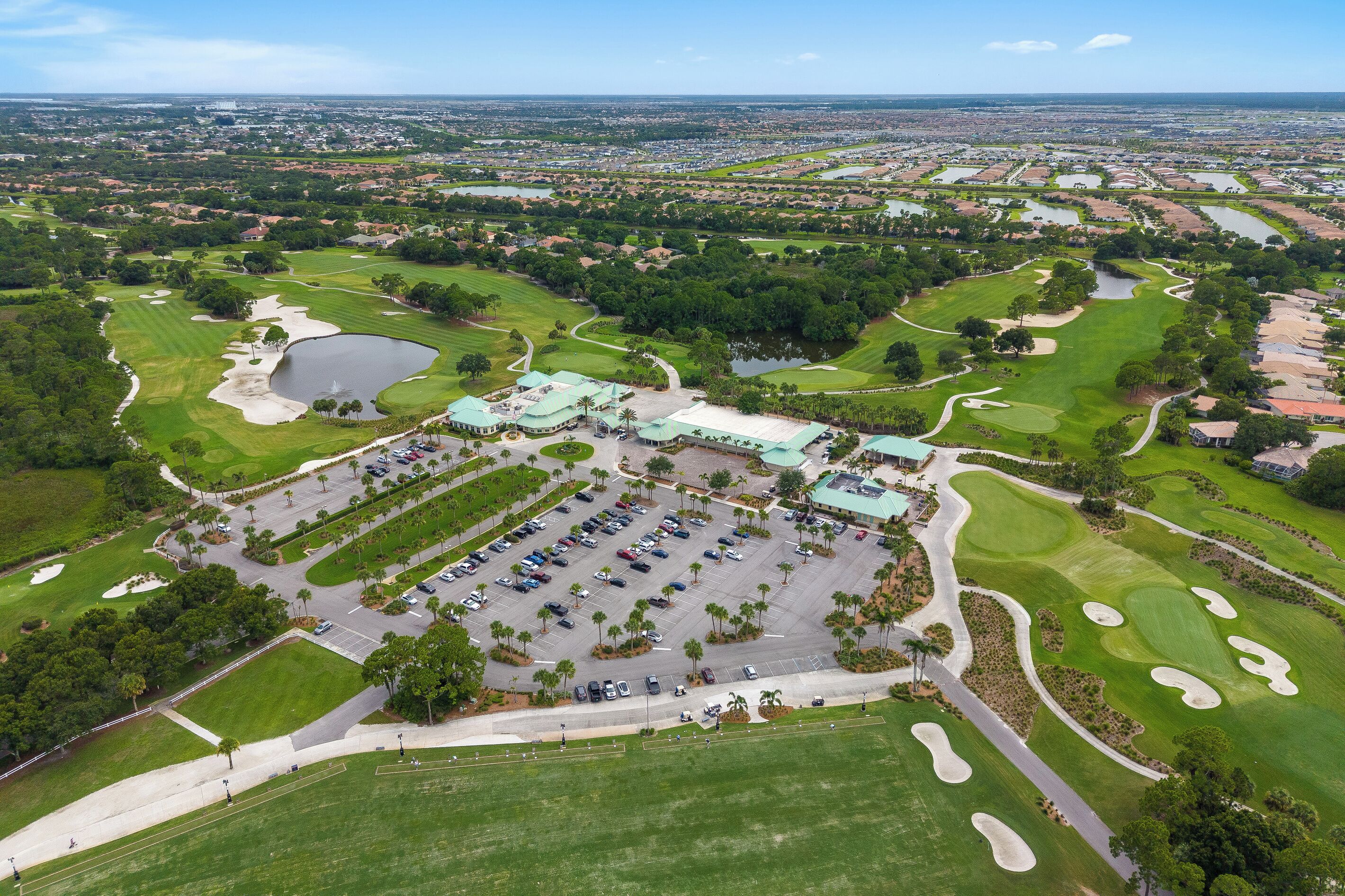 Un terrain de golf doté d’un parking, d’un club-house et entouré de zones résidentielles.