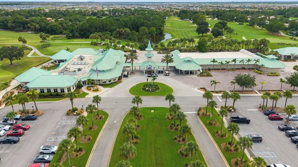 A golf course with a building featuring a green roof and a central clock tower. - Right Direction Rentals 1 Bedroom Villa 9906 (Port St. Lucie)