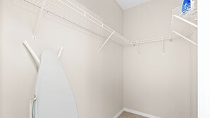 A laundry room with a white iron, a drying rack, and a blue appliance on the wall. - Right Direction Rentals 1 Bedroom Villa 9906 (Port St. Lucie)