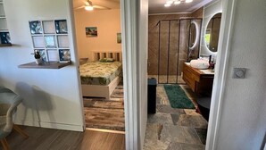 Un dormitorio con cama, cómoda, espejo y una pequeña zona de escritorio.