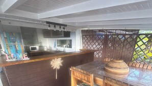 Una cocina moderna con una isla de madera, taburetes de bar y un letrero decorativo.