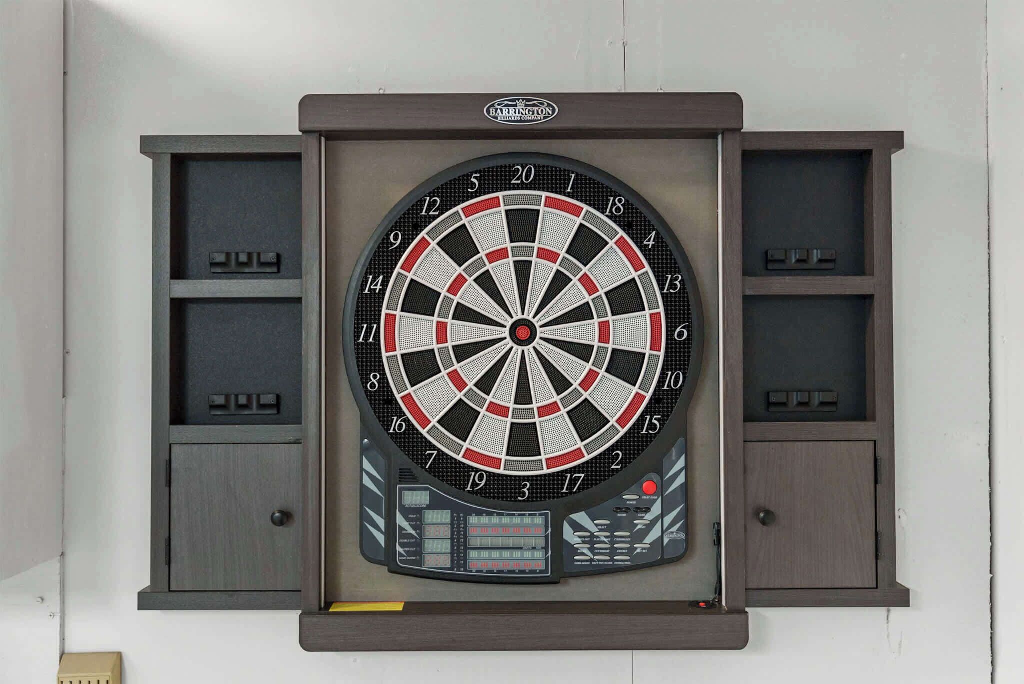 A dartboard mounted on a wall with a digital score display below it.