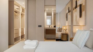 A hotel room with a bed, a wardrobe, a mirror, and a nightstand with a lamp. - Stylish 2BR in Estepona, Walk to Beach & Old Town (Estepona)