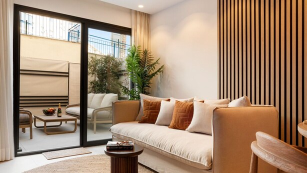 A modern living room with a sofa, armchairs, a coffee table, and a small side table. - Stylish 2BR in Estepona, Walk to Beach & Old Town (Estepona)