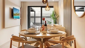 A modern dining area with a round table, chairs, and a hanging light fixture. - Stylish 2BR in Estepona, Walk to Beach & Old Town (Estepona)
