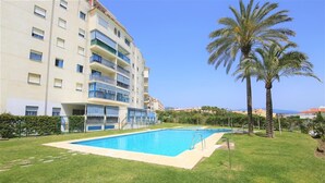 A hotel with a swimming pool, palm trees, and a clear blue sky. - Stylish 2BR in Estepona, Walk to Beach & Old Town (Estepona)