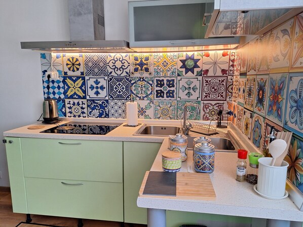 Refrigerador, cafetera y tetera, utensilios de cocina y condimentos 