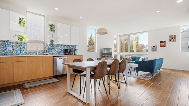 A modern kitchen with wooden cabinets, a stainless steel dishwasher, and a blue mosaic backsplash. - The Rooftop Blue Haven Home w Firepit (Seattle)
