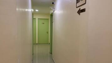 A hallway with a green door, a sign with the number 201-205, and an arrow pointing to the left.