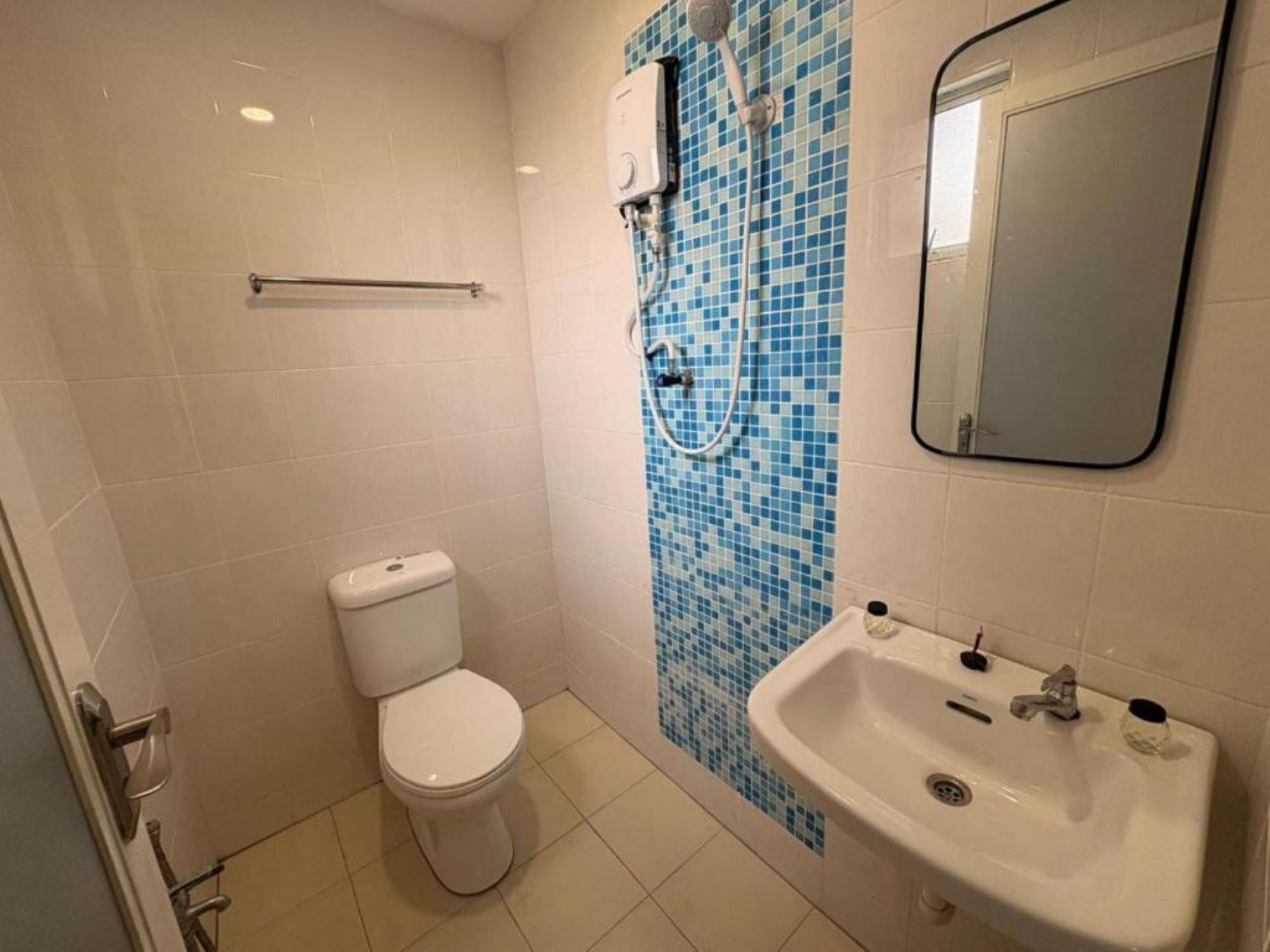 A small bathroom with a toilet, a sink, and a shower.
