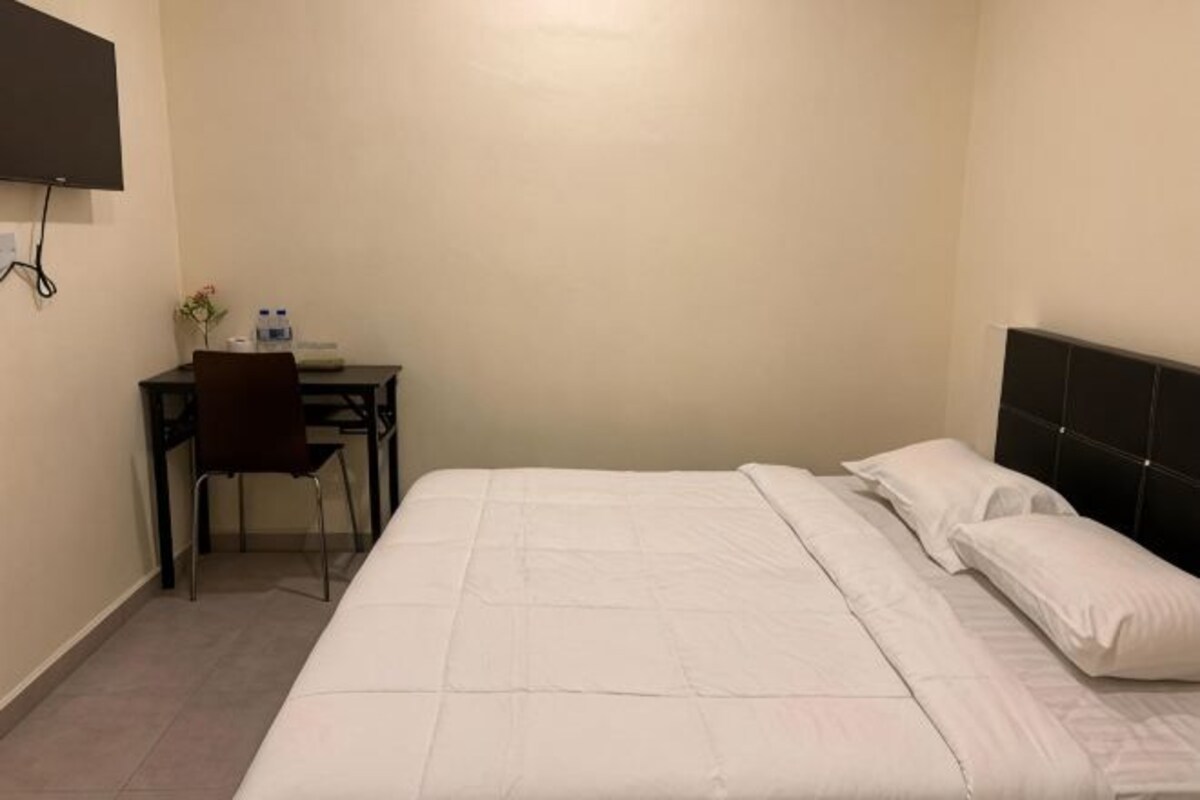 Een hotelkamer met een bed, een bureau en een stoel.