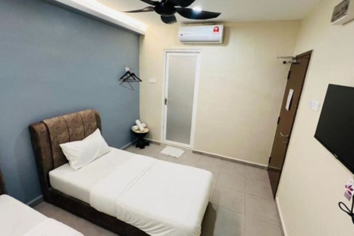 Une chambre à coucher avec un lit, un ventilateur de plafond, un climatiseur, une porte et un téléviseur.