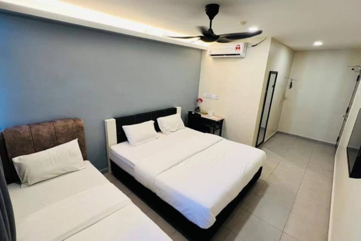 A hotel room with two beds, a ceiling fan, an air conditioning unit, and a TV.